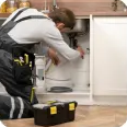 Plumber working under a kitchen sink