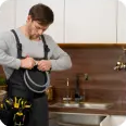 Plumber preparing tools in a kitchen