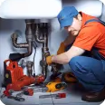 Plumber repairing pipes under a sink